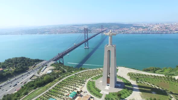 Aerial view of Sanctuary of Christ the King overlooking Lisbon and 25 de Abril Bridge connecting Lis