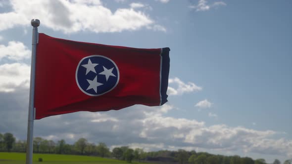 Flag of Tennessee Waving in the Wind Against Deep Beautiful Clouds Sky
