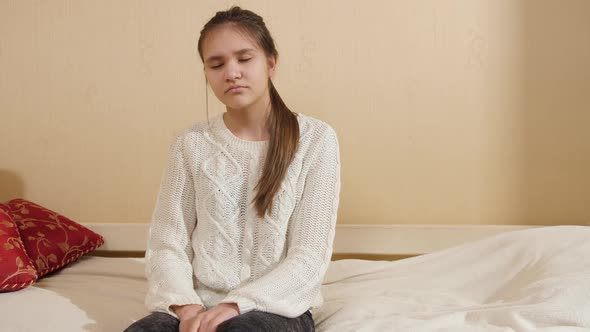 Tired and Exhausted Teenage Girl Sitting on Bed and Falling on Pillow