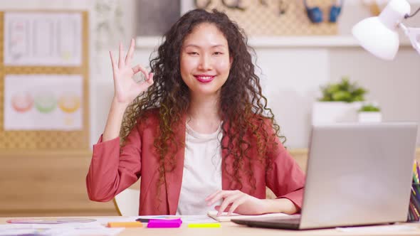 Excited young woman in red blazer posing isolated on working space. Pointing index fingers aside sho