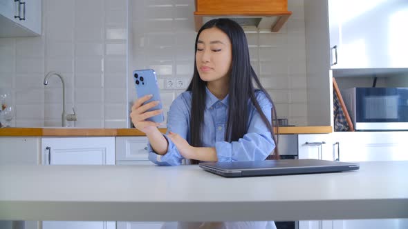 Asian girl doing video call over internet with mobile phone. Woman talking on the phone