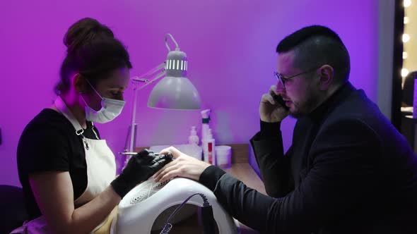 A Man Has His Nails Done in a Nail Salon - Master Pushing His Cuticle with a Pusher