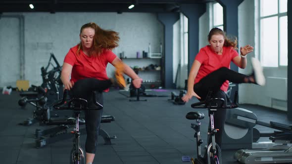 Healthy Caucasian Group of Women Exercising Workout on Stationary Cycling Machine Bike in Gym