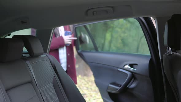 Young Woman in Protective Mask Entering Taxi Sitting Down on Passenger Seat