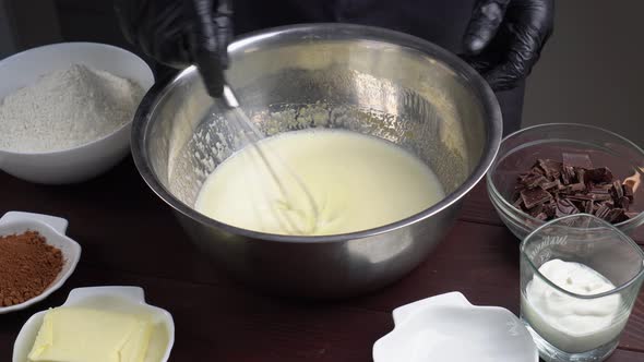 Closeup View of Male Hands Preparing Dough Mixing Flour with Other Ingredients Using Whisk in