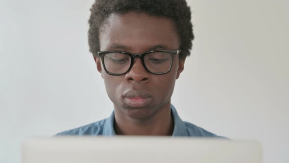 Close Up of Young African Man Using Laptop in Office