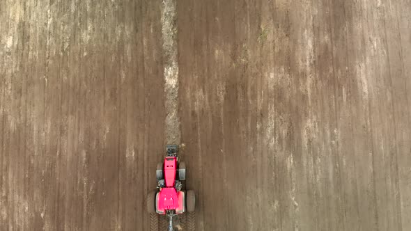 Farmer Uses a Modern Tractor with a Disc Harrow To Process Brown Fertile Soil