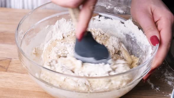 Baker Mixing Carrot Cake Batter On Bowl With Spatula. - high angle