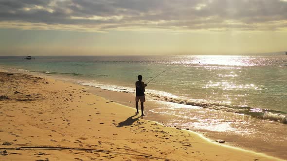 Man alone happy and fishing on luxury bay beach time by aqua blue ocean and white sandy background o