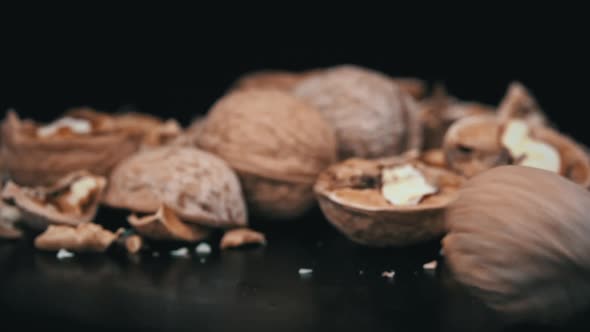 Whole Walnut Rolls in Slow Motion Against a Background of Pile of Nuts in a Loop