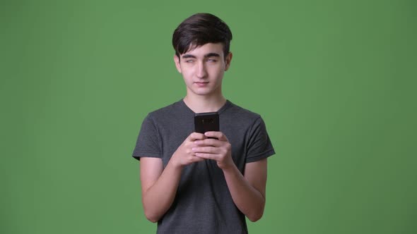 Young Handsome Iranian Teenage Boy Against Green Background