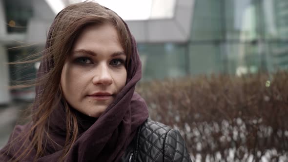 Charming Young Woman with Scarf on Head is Standing on Street of City at Cold Day Portrait of Lady