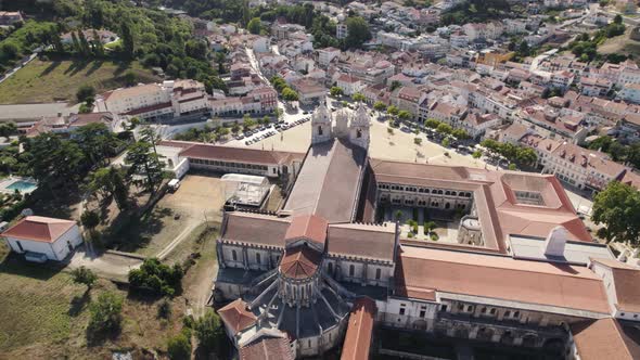 Aerial pan shot above historical complex Alcobaça monastery overlooking at parish townscape.