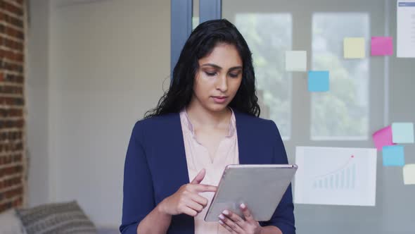 Portrait of woman using digital tablet at office