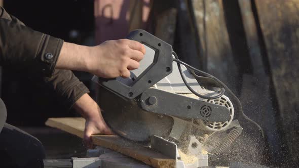 Man Saws Boards with a Circular Saw