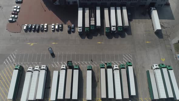 Buildings of Logistics Center Warehouses Near the Highway View From Height a Large Number of Trucks