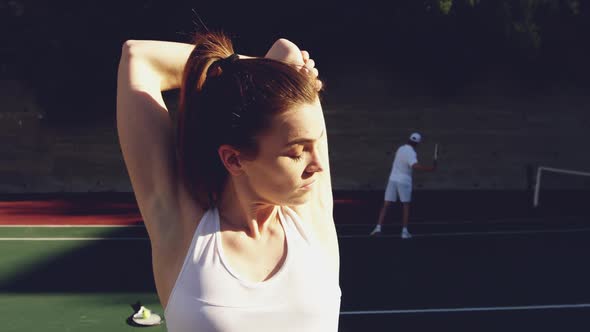 Woman and man playing tennis on a sunny day