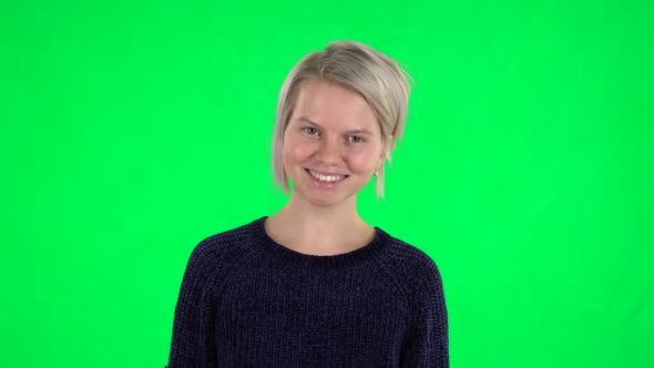 Portrait of Blonde Girl Looking Straight and Laughing on a Green Screen