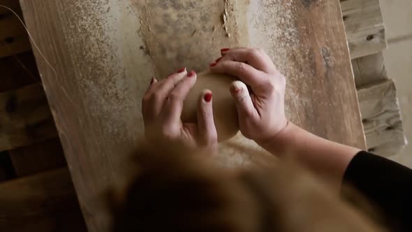 Top Footage of Female Hands with Beautiful Red Manicure Holding Clay and Kneading It on a Worktop