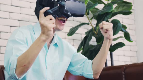 Excited handsome man wearing virtual reality glasses playing the game simulation.