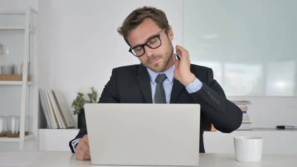 Businessman with Neck Pain Working on Laptop