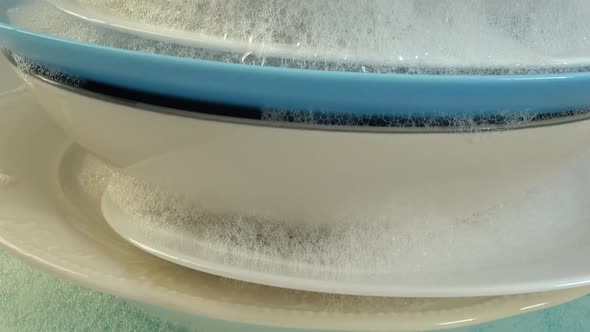 A stack of soapy dishes in foam