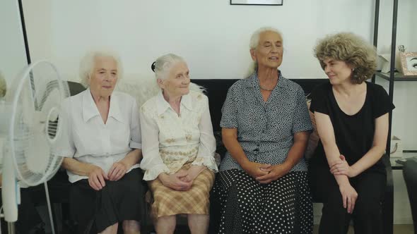 View of Four Mixed Age Women Having Pleasant Talking on Sofa in Room