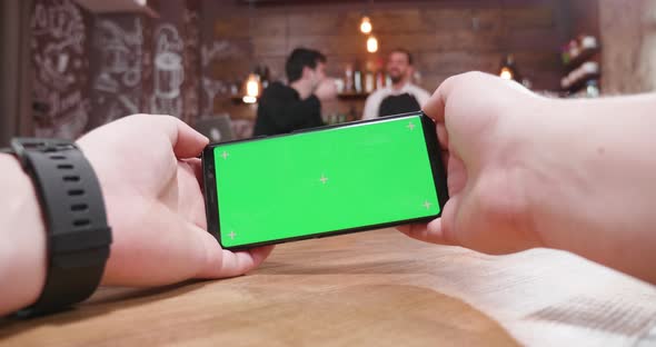 POV Footage of Male Hands Playing a Video Game at a Table in a Vintage Cafe