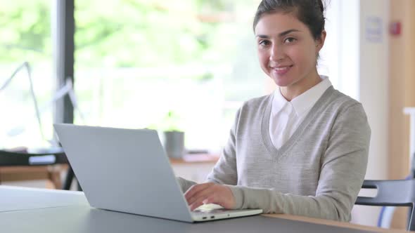 Cheerful Indian Woman with Laptop Smiling at Camera