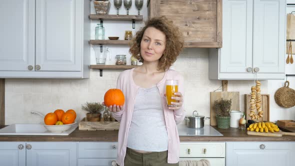 Pregnant Woman With Glass Of Orange Juice In The Kitchen