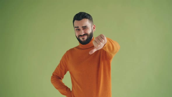 Portrait of Unhappy Hipster Showing Thumbs-down Gesture Looking at Camera