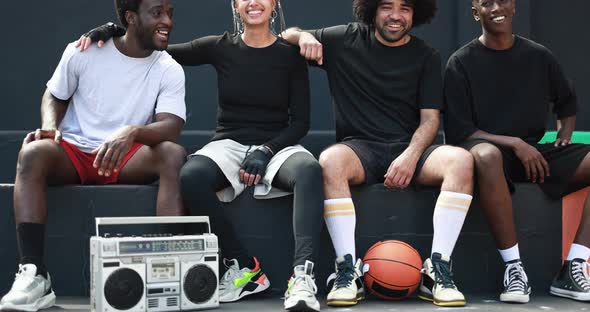 Group of young multiracial people listening music from vintage boombox stereo in the city