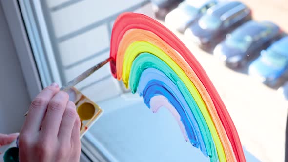 Girl Painting Rainbow on Window During Covid19 Quarantine at Home