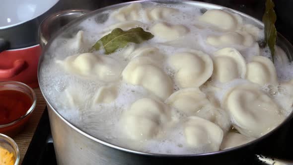 Dumplings Boiled in Hot Water in Saucepan with Bay Leaf on Domestic Kitchen