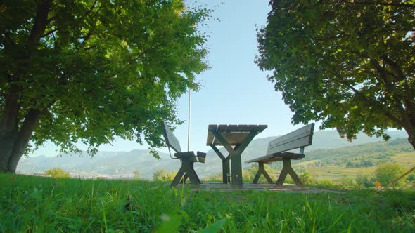 Wooden Benches with Table on Lawn Against Mountain Valley