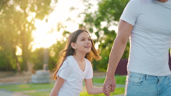 Dad and Daughter Walk Around Their Area at Sunset