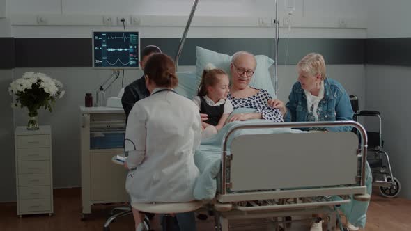 Medic Showing x Ray Results to Woman in Hospital Ward