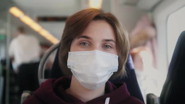 Close Up Portrait of Female Student in Medical Mask at Public Transport Looking to Camera