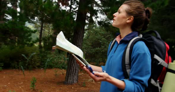 Side view of hiker walking with a map and compass