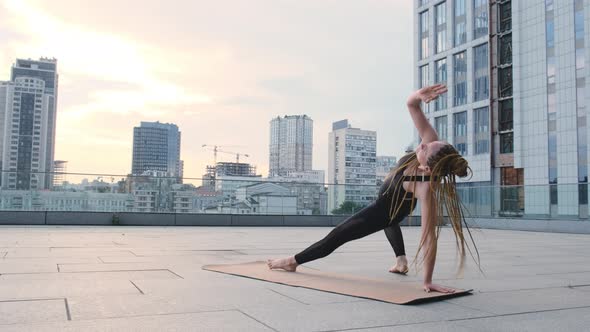 Fitness Woman Practices Yoga Outdoots at Urban Spaces