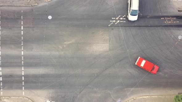 Top down aerial view of city traffic with cars moving on a street at roads intersection.