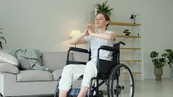 Young Woman is Spreading Her Arms in Different Sides in Wheelchair