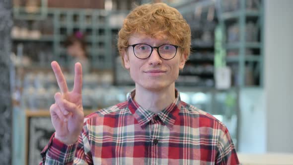 Young Redhead Man with Victory Sign By Hand 