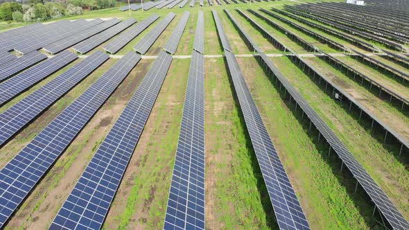 Aerial View of Solar Power Station in Green Field on Sunny Day