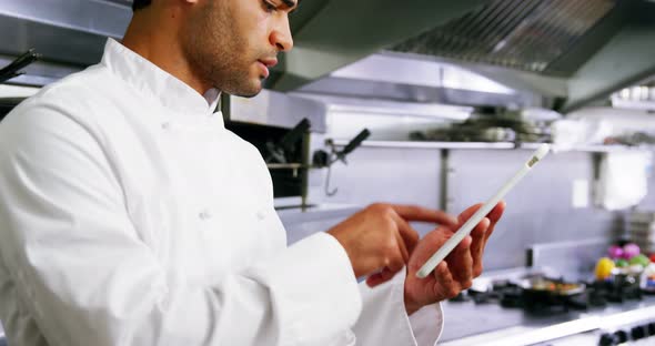 Male chef using digital tablet in commercial kitchen