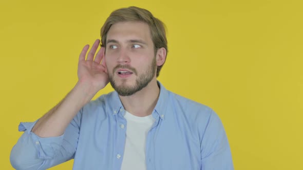 Young Man Trying to Listen Secret Yellow Screen