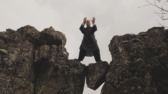 Kung Fu Master Performing Poses On Rocks In Iceland