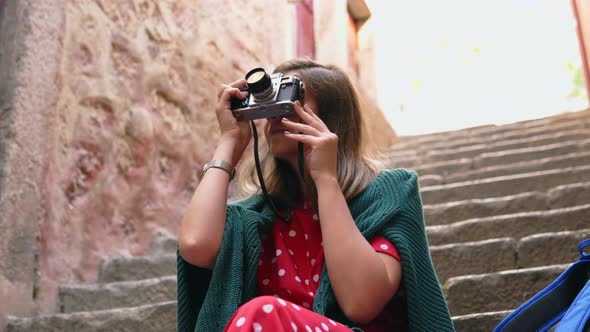 Woman Is Sitting and Taking Photos of Ancient Building on Vintage Camera