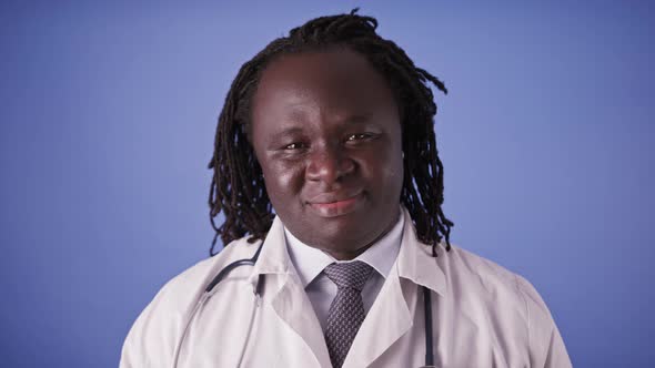 Portrait of an African Doctor in White Coat Isolated on Blue Studio Background