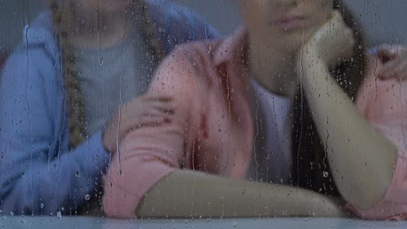 Little Girl Comforting Mother Sitting Near Rainy Window, Depressed After Divorce